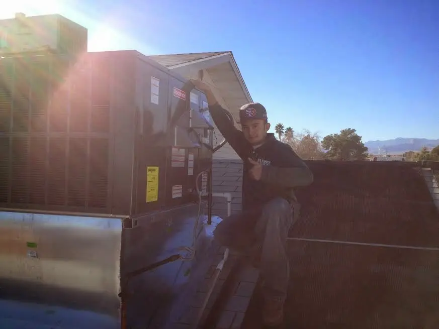 HVAC technician performing HVAC Inspection on a rooftop unit in International Falls